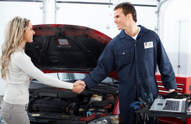 mechanic and female customer shaking hands