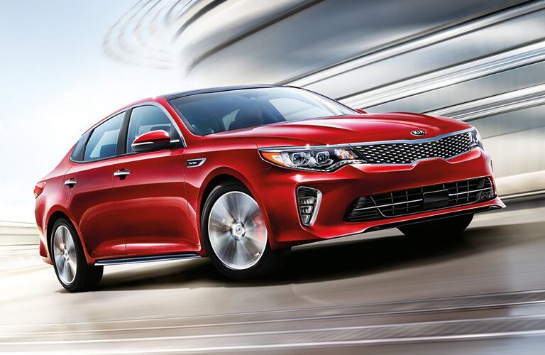 red Kia Optima driving