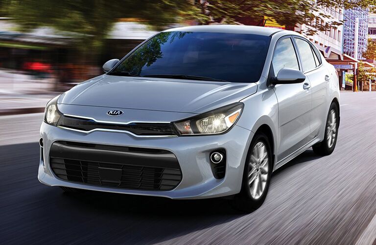 silver Kia Rio driving