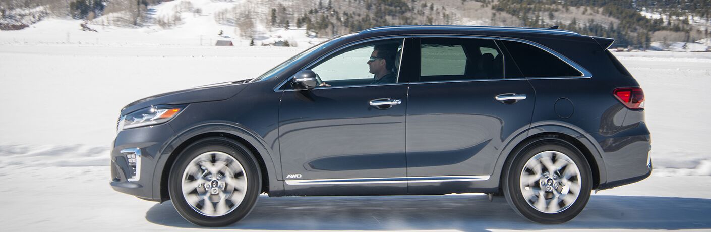 2019 Kia Sorento exterior side shot with man in driver's seat driving through a snowy landscape