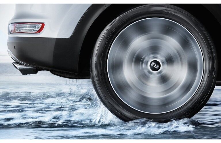 2019 Kia Sportage close up of front wheel spinning on a snow covered icy terrain