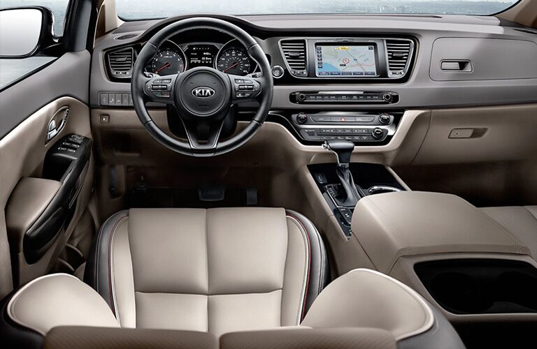 2021 Kia Sedona minivan interior shot of front seating, steering wheel, transmission, and dashboard layout