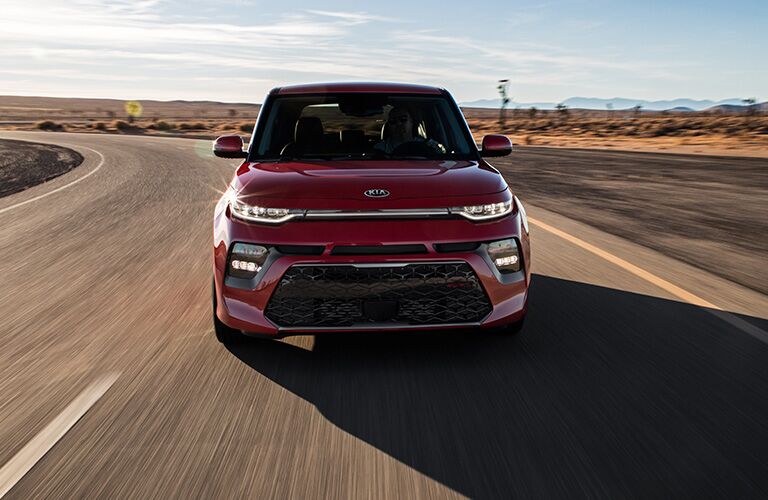 2020 Kia Soul exterior front shot with red paint color driving down a desert highway