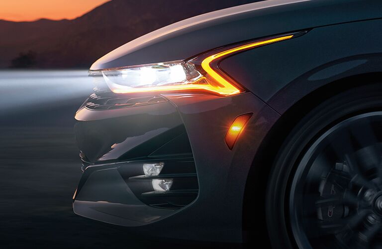 2021 Kia K5 midsize sedan exterior closeup shot of front grille, bumper, and headlight design