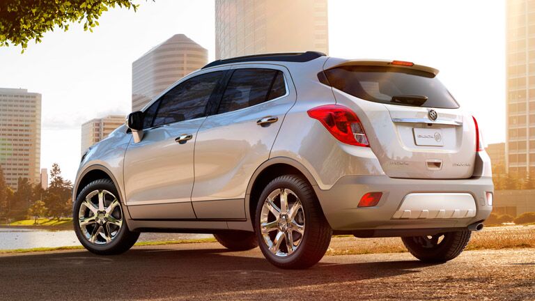 shiny white 2015 Buick Encore SUV in front of a city and skyscrapers