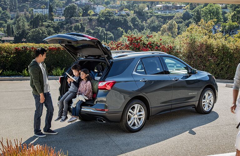 Two kids sitting in rear cargo area of 2019 Chevrolet Equinox