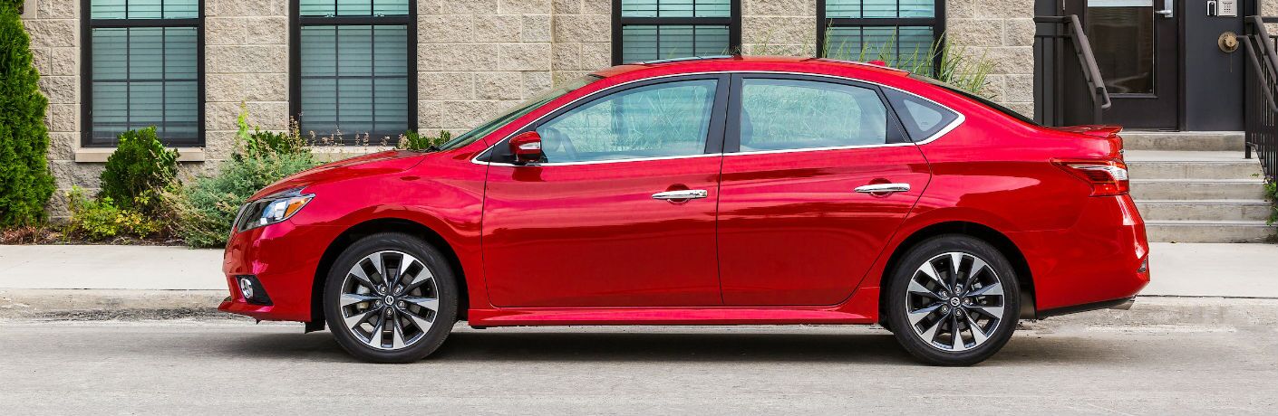 A left profile photo of the 2019 Nissan Sentra in front of a building.