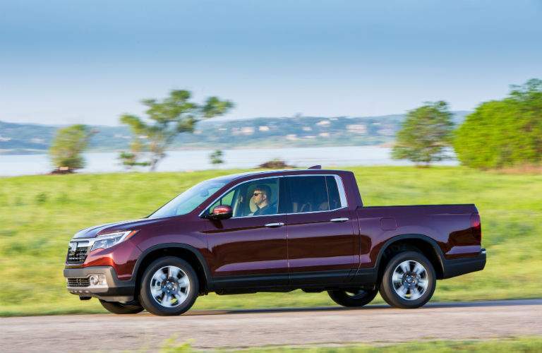 A left profile view of a 2018 Honda Ridgeline driving on a road.