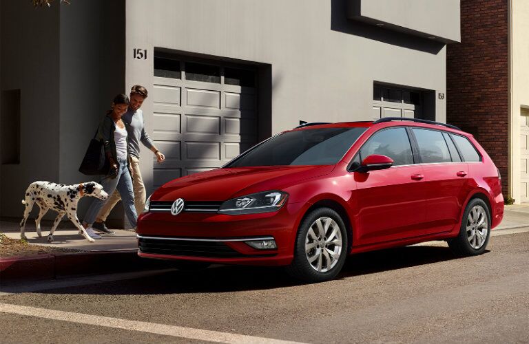 Red 2019 Volkswagen Golf SportWagen parked outside a garage