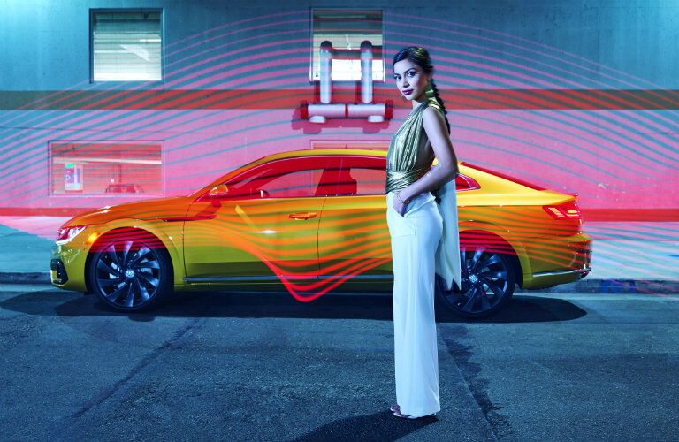 Fashion model standing in front of the side profile of the 2019 VW Arteon photographed by Douglas Sonders