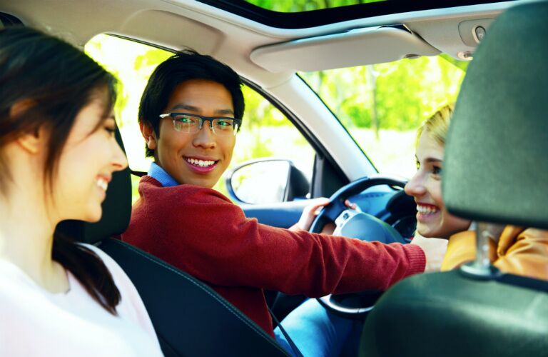 driver with friends in new car