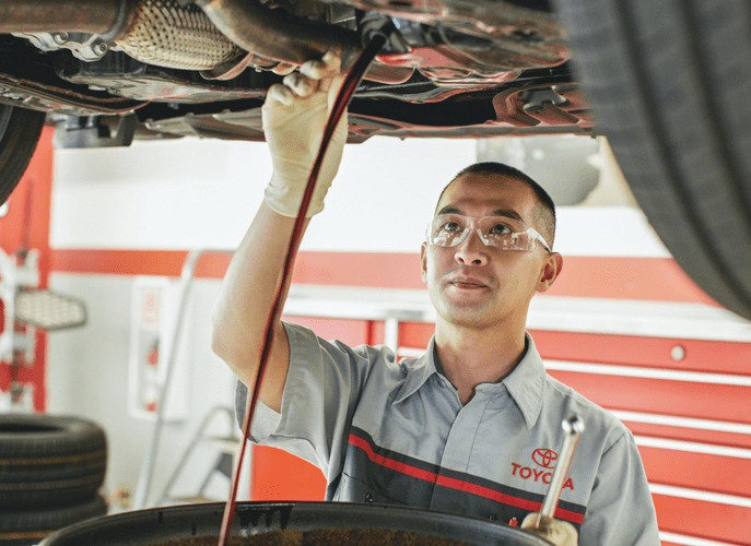 Toyota Technitian Working on the Underbody of a Vehicle