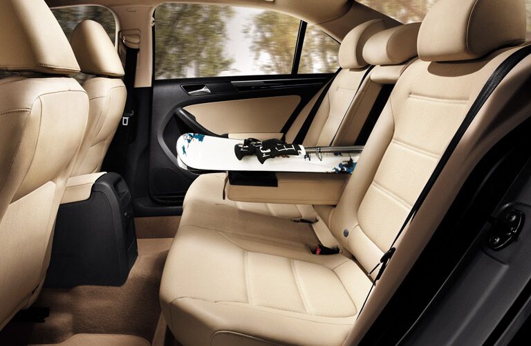 View of the 2017 Volkswagen Jetta's backseat with a snowboard between the seats from the trunk