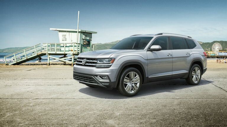 2019 Volkswagen Atlas exterior shot with silver paint color parked near a beach shore lifeguard post