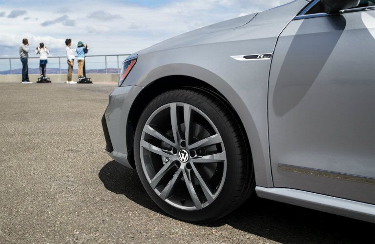 2019 Volkswagen Passat SE R-Line trim exterior close up shot of front wheel parked on a gravel cliff near tourists on telescopes