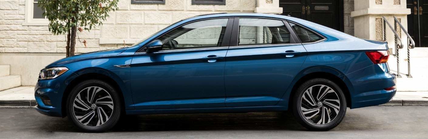 Side profile of the 2019 VW Jetta parked next to a tree in a city
