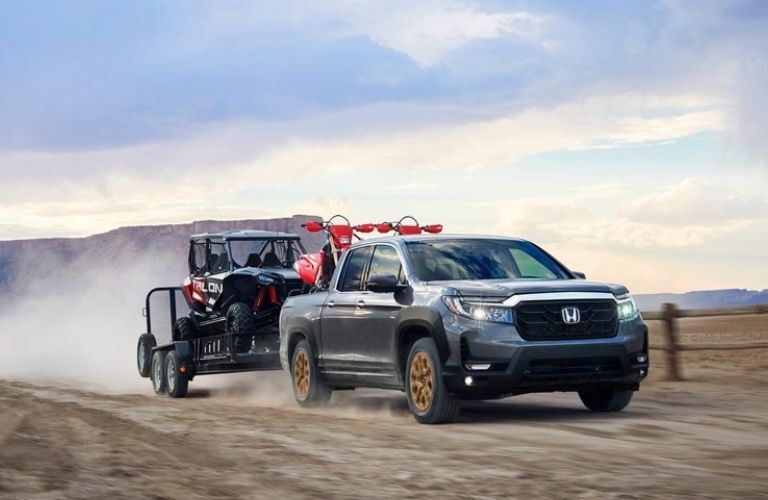 2021 Honda Ridgeline towing a trailer with a vehicle in it