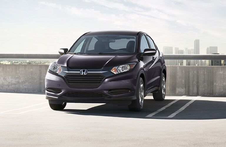 Purplish Honda HR-V parked on the top level of a parking garage on a foggy day.