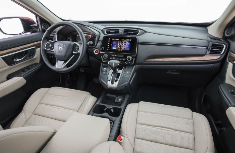 A photo showing the driver's cockpit including steering wheel, gauge cluster and infotainment system in the 2018 CR-V.