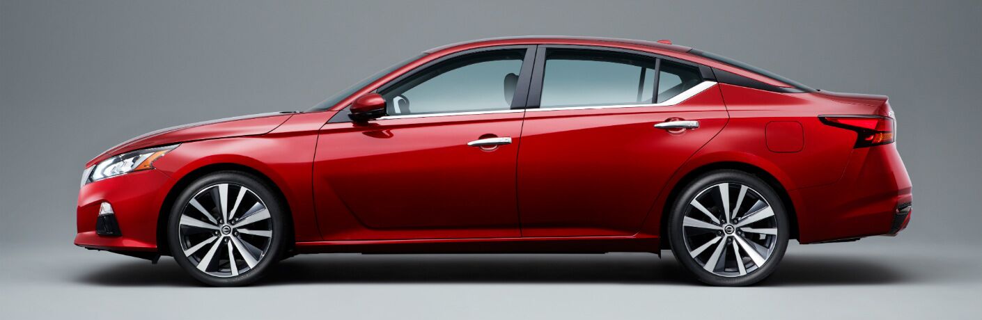 Side view of a red 2018 Nissan Altima on a grey background