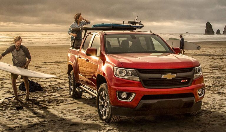 Red Chevy Colorado midsize truck on the beach