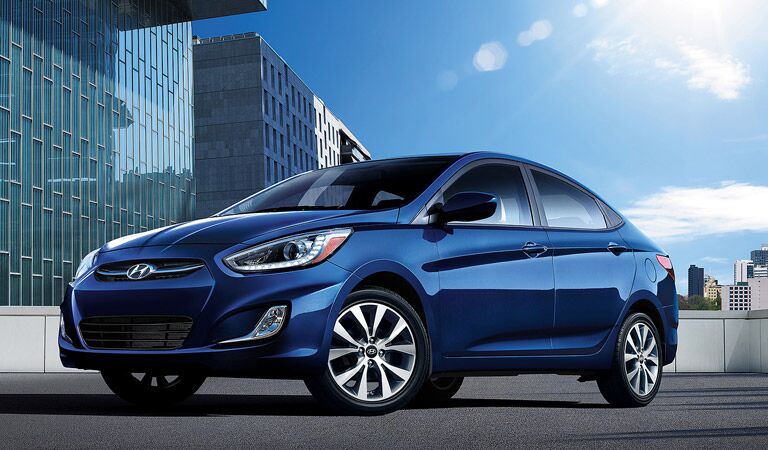 blue 2016 Hyundai Accent in front of skyscrapers