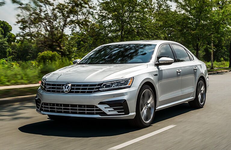 silver Volkswagen Passat driving by trees