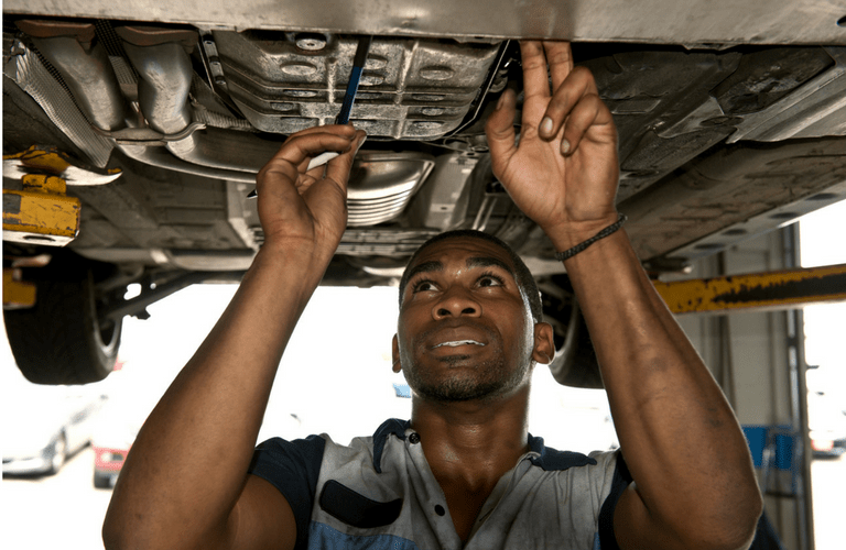 Mechanic looking under car