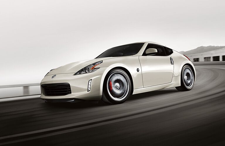 white Nissan 370Z going fast around a highway corner
