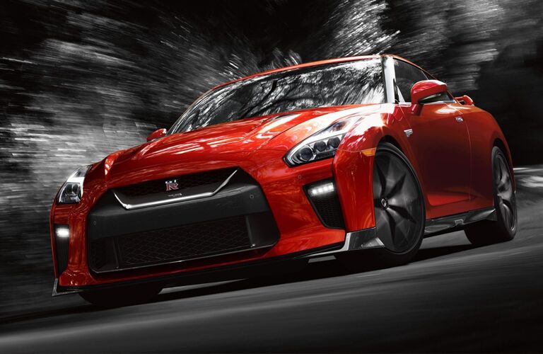 red Nissan GT-R turning a corner on a back road highway