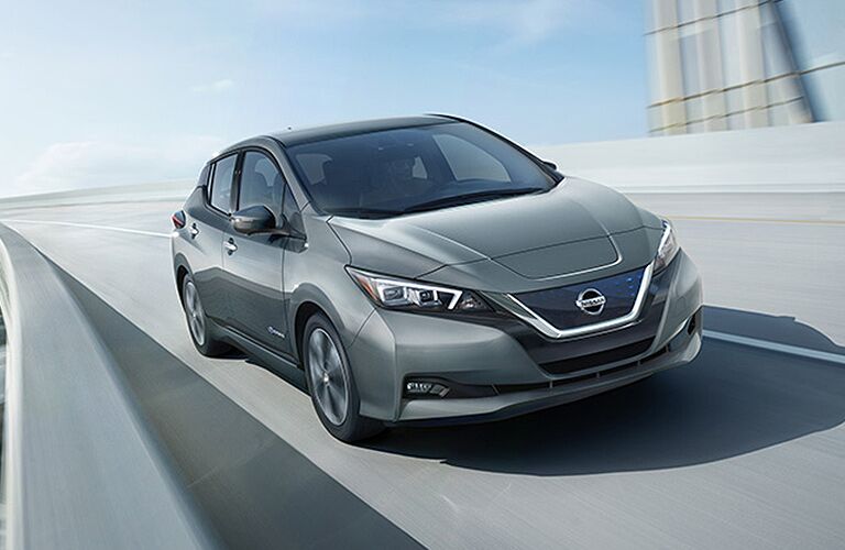 silver Nissan Leaf driving fast on a highway