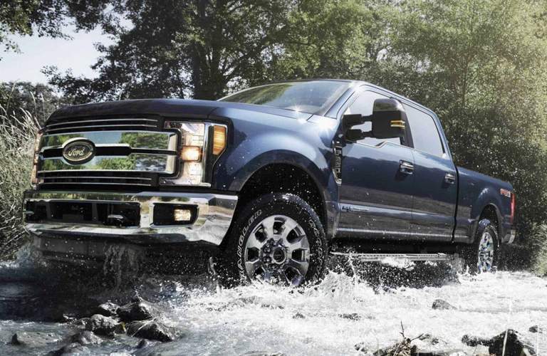 blue 2018 Ford F-250 Super Duty driving dramatically through water