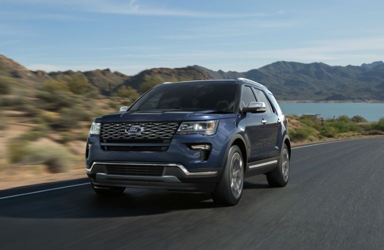 2018 Ford Explorer on the road, mountains and a lake in the background