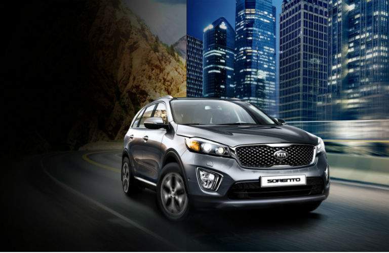 2018 kia sorento in silver driving in a city at night