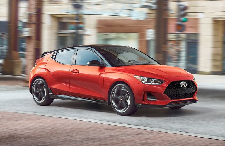 2020 hyundai veloster turbo orange exterior front passenger side driving in city