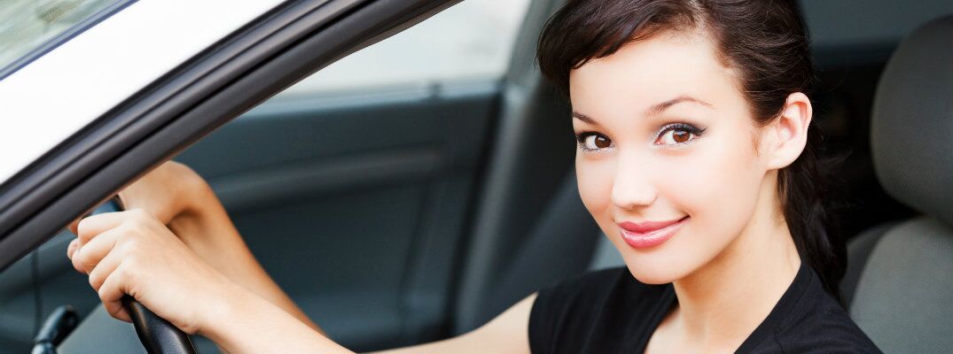 Woman in black shirt behind the wheel of a used vehicle