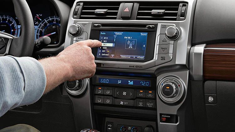 Infotainment Man's hand touching the tech display panel on a 2019 Toyota 4Runner