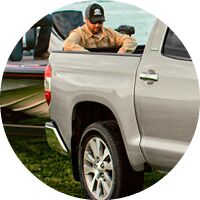 man behind 2017 Toyota Tundra truck bed getting out fishing gear