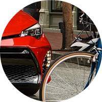 front grille of red 2018 Toyota Corolla and front wheel of bicycle