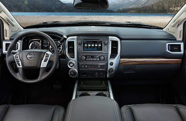 Steering wheel and center touchscreen of Nissan Titan pickup with front row of seating visible
