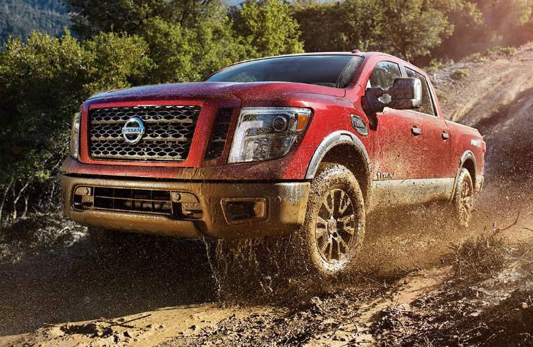 Red 2017 Nissan Titan driving down muddy hill