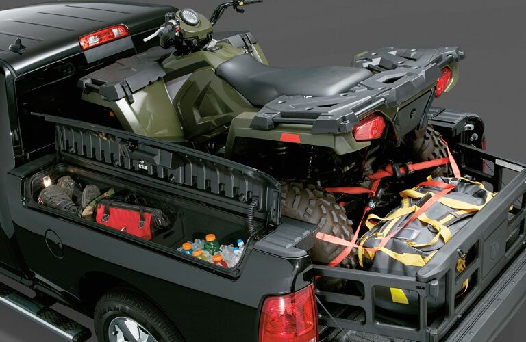 ATV parked in back of 2018 RAM 1500 with cargo management systems prominent