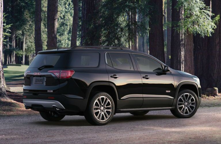 Black 2017 GMC Acadia in the woods