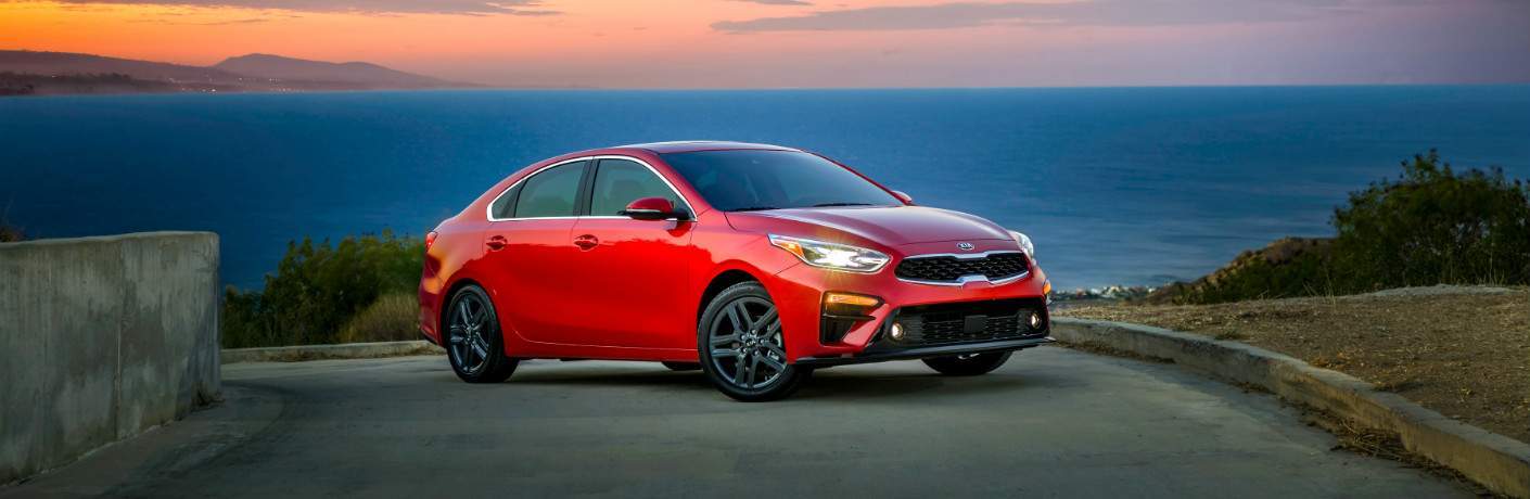 red 2019 Kia Forte parked on slope overlooking water body