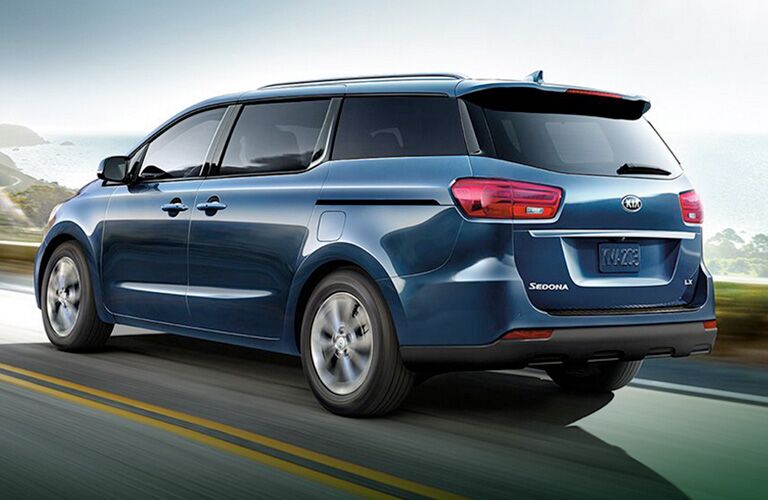 Blue 2020 Kia Sedona driving on a coastal road