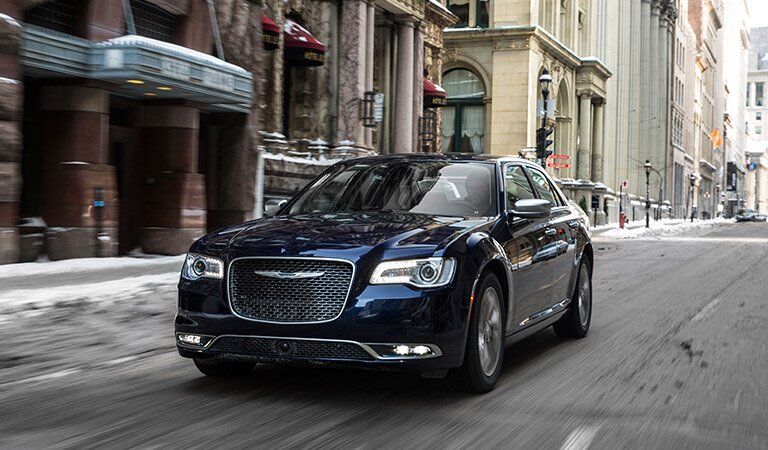 stylish dark Chrysler 300 driving through the city