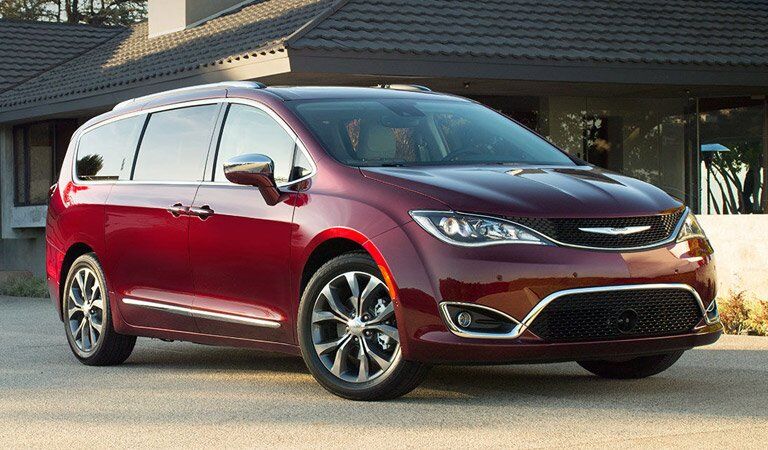 red Chrysler Pacifica parked outside an attractive home