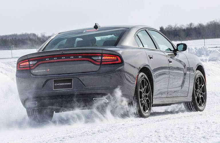 rear view of a grey 2018 Dodge Charger driving in snow