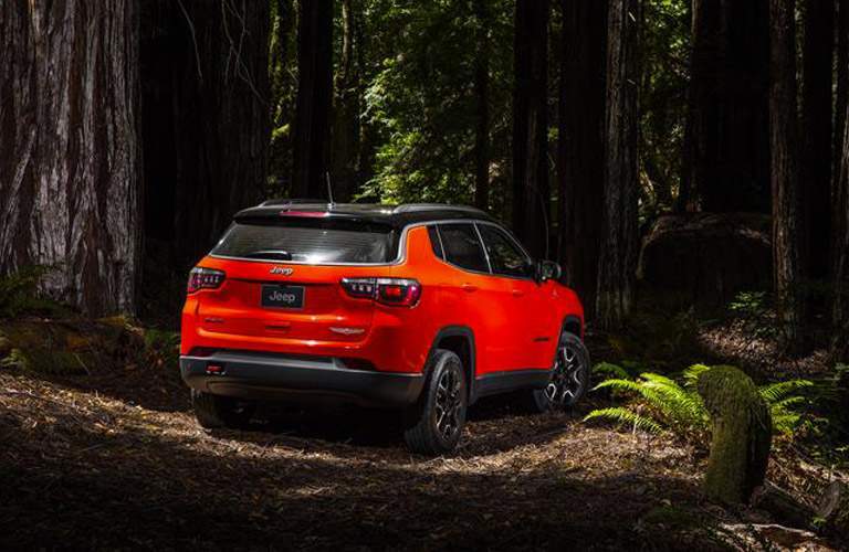 rear view of an orange 2018 Jeep Compass in the woods