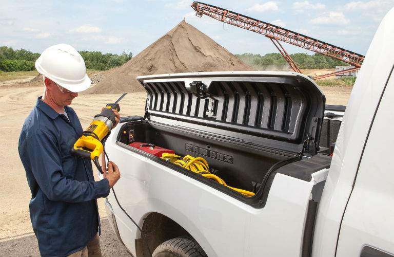 man with a power tool and a hard hard taking tools from the RamBox on the 2018 Ram 1500